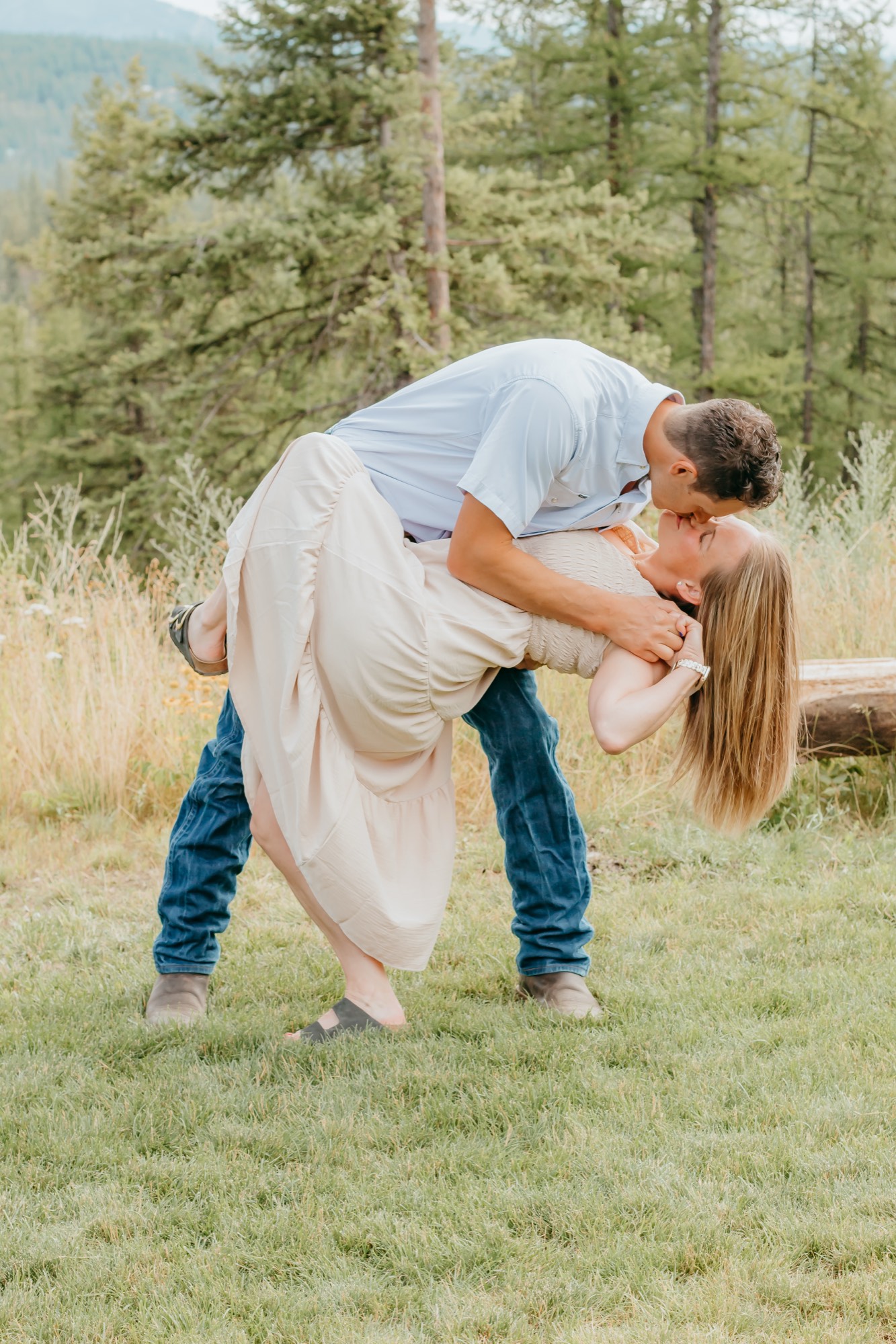 Couple dip kissing in a mountain meadow during a couples photo session in North Idaho