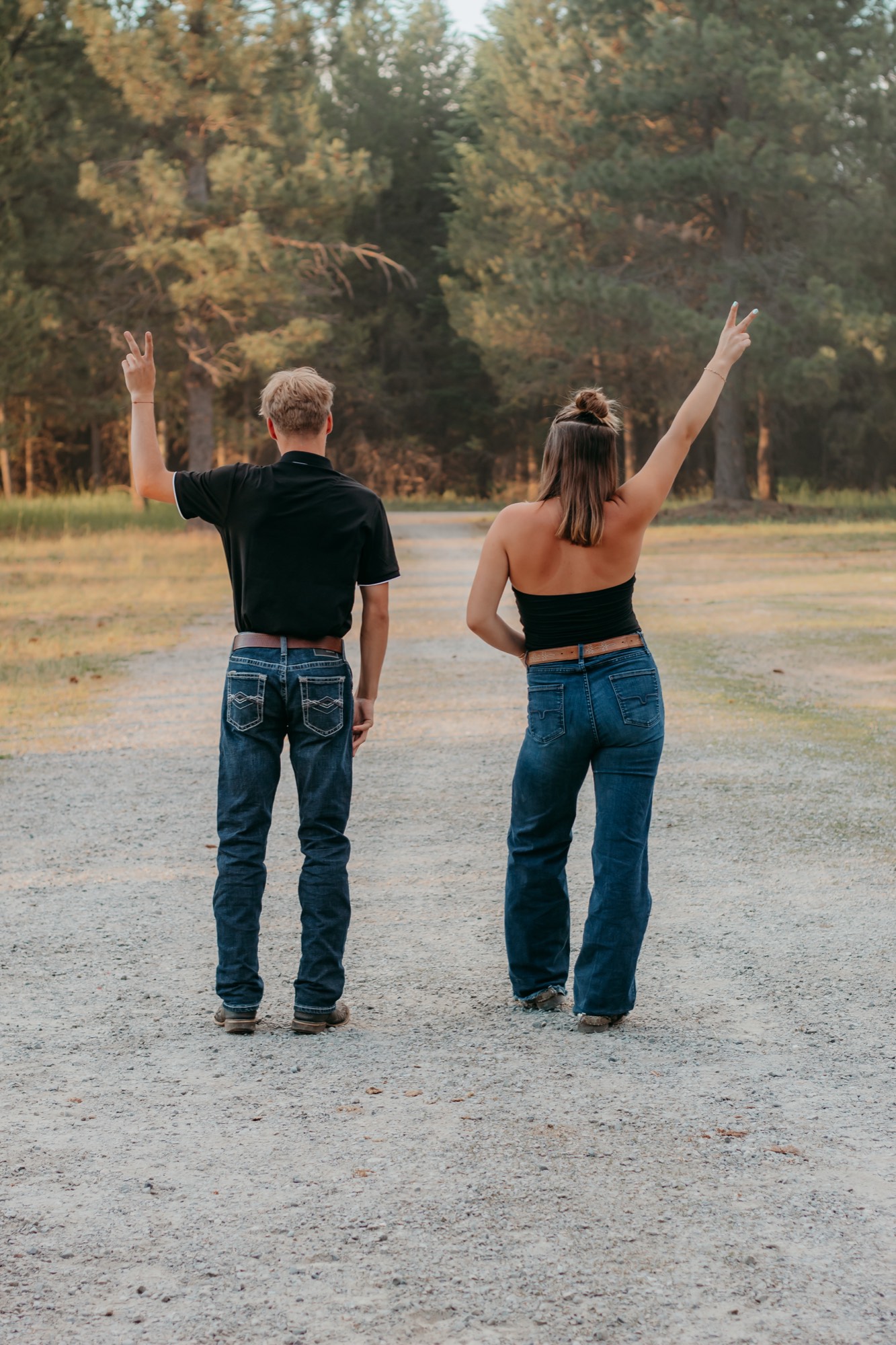 Two seniors throwing peace signs on a country road in North Idaho